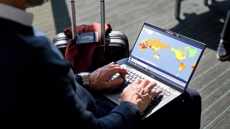 male business traveller at airport looking at risk map in his pc
